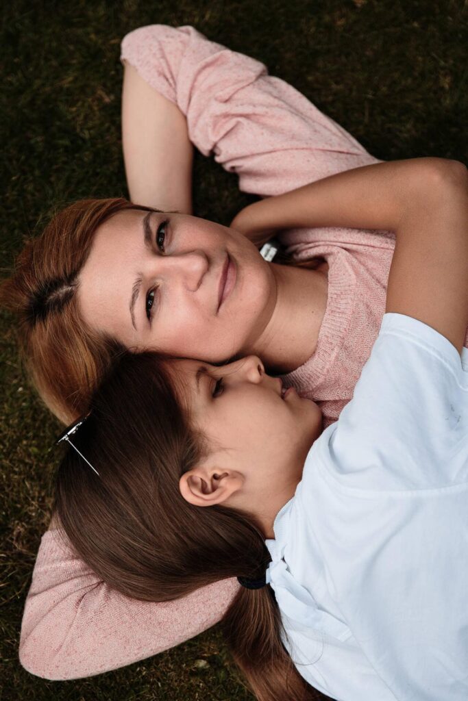 Мама и дочь лежат на траве