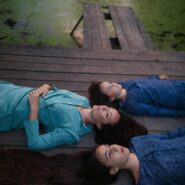 Мама и дочери на мостике у водоёма на закате