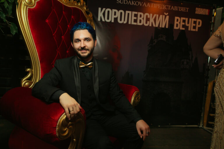 Мужчина в смокинге на красном троне