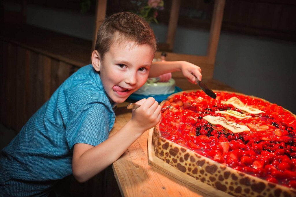 Ребенок с гигантским ягодным тортом на празднике