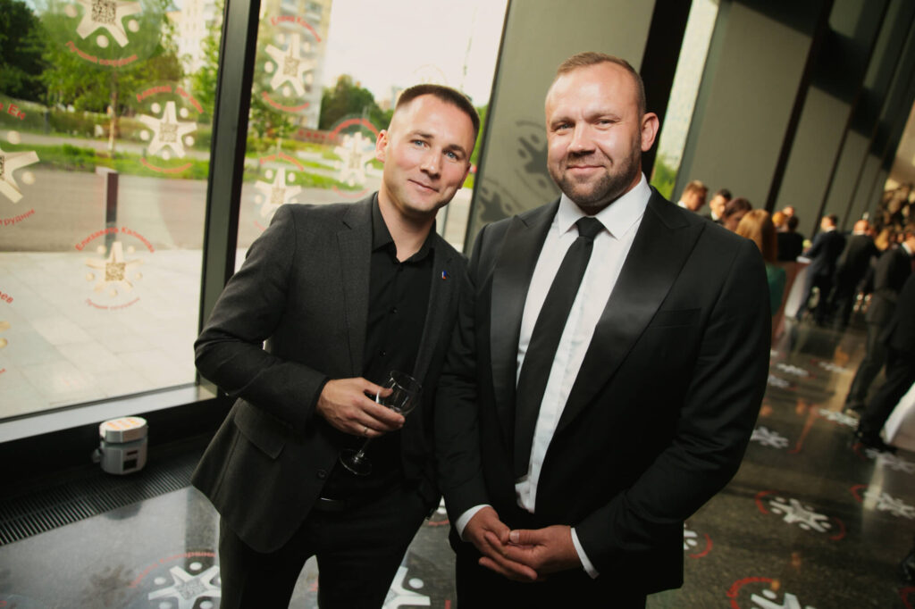 Двое мужчин в строгих костюмах на светском мероприятии