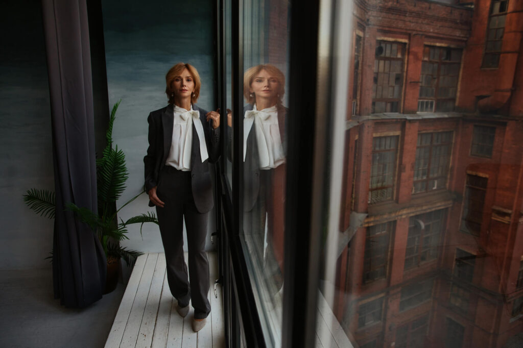 Женщина у окна: отражение в стекле