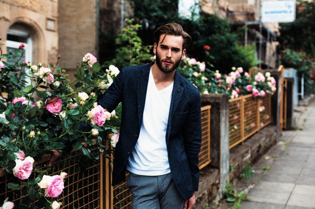Парень в синем пиджаке рядом с розами
