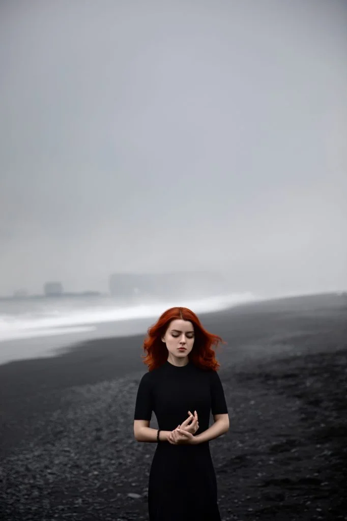 Красивый портрет рыжей девушки в Исландии, пляж с черным песком
