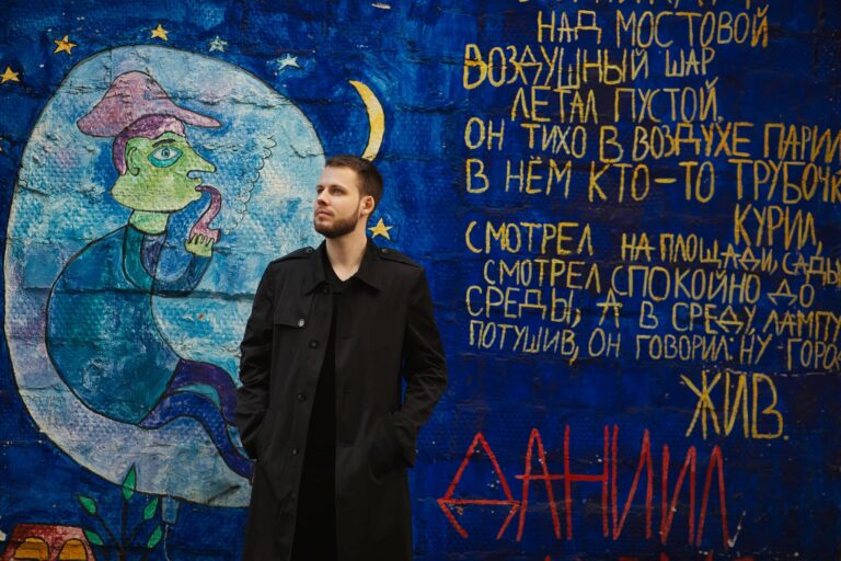 Стоит у граффити с текстом и луной