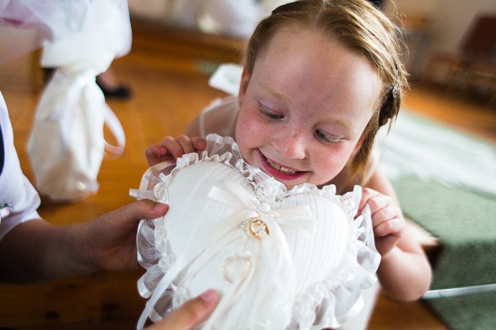 Девочка держит подушечку с обручальными кольцами