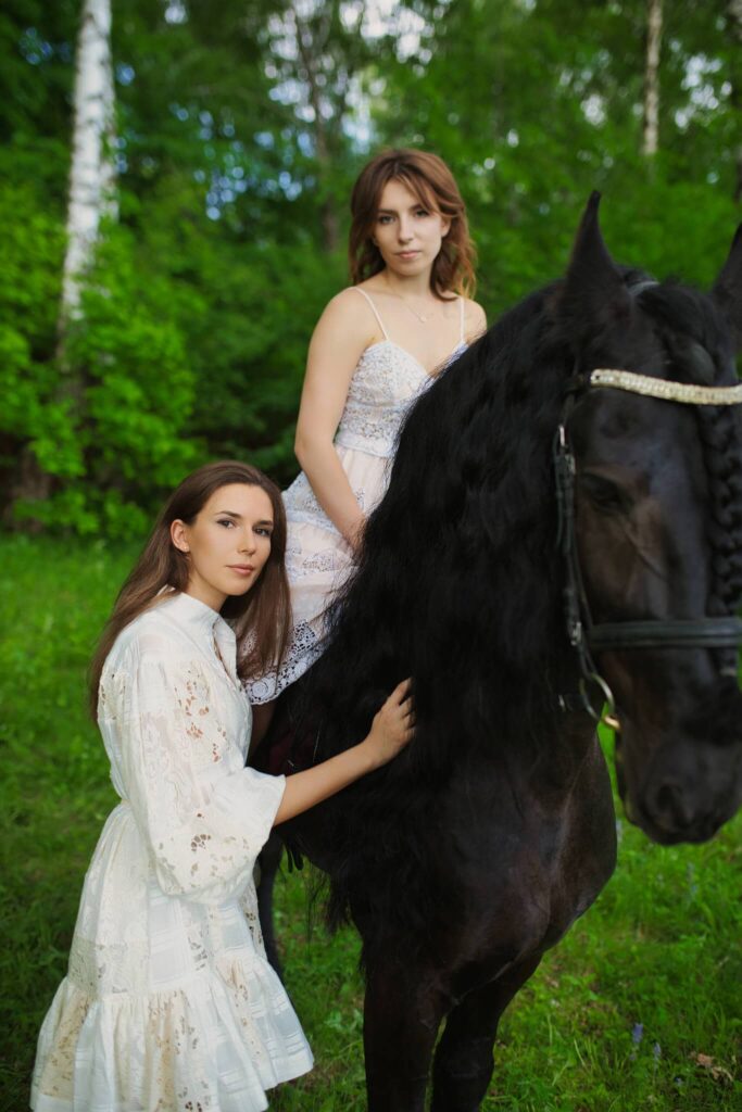 Позирование с черным конем на зеленом фоне