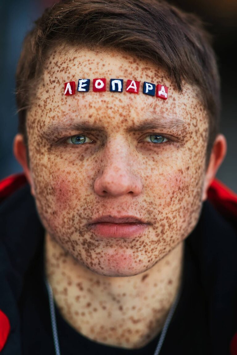 Портрет мужчины с веснушками, на лбу выложено буквами слово «Леопард» — фотопроект «Клеймо»